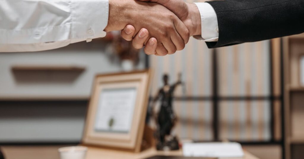 Close-up of a handshake between two professionals in a modern office setting, emphasizing partnership and agreement.